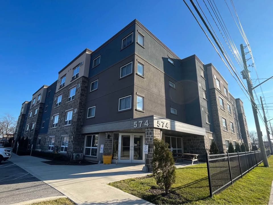 Modern four-storey apartment building on King Street with a fenced front lawn