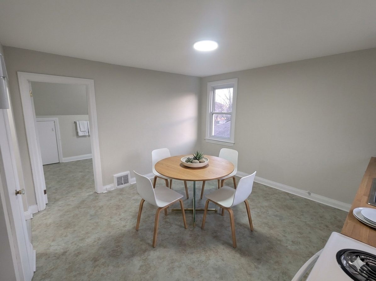 Eating area with a round table beside the kitchen (virtually staged)